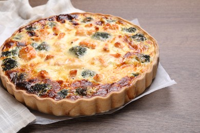 Delicious homemade quiche with salmon and broccoli on wooden table