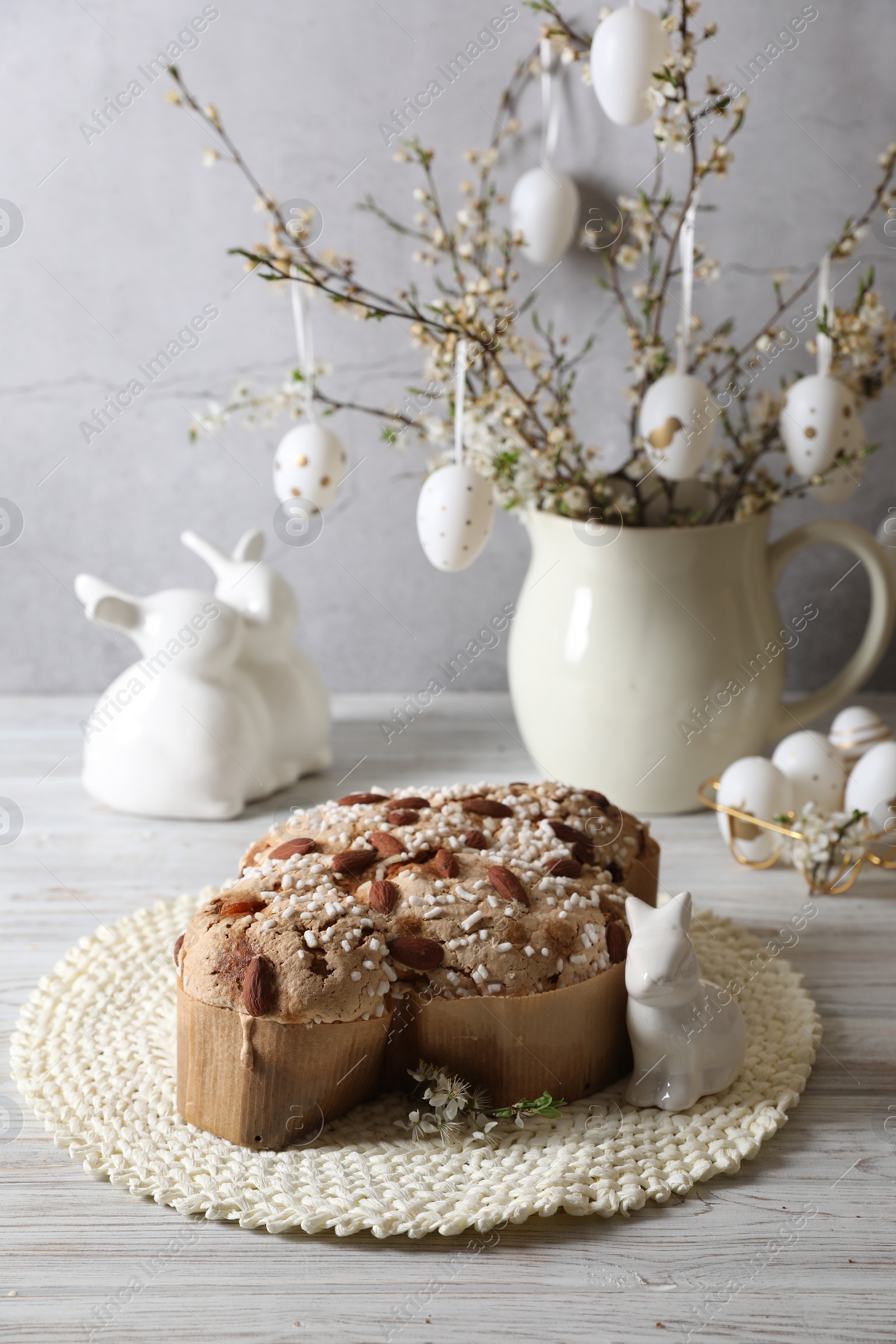 Photo of Delicious Italian Easter dove cake (Colomba di Pasqua) and festive decor on white wooden table