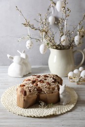 Photo of Delicious Italian Easter dove cake (Colomba di Pasqua) and festive decor on white wooden table