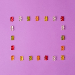 Photo of Flat lay composition with delicious jelly bears on color background. Space for text