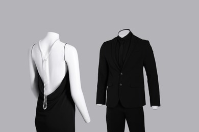 Photo of Male and female mannequins dressed in elegant outfits on grey background