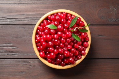 Photo of Fresh cranberry on wooden table, top view