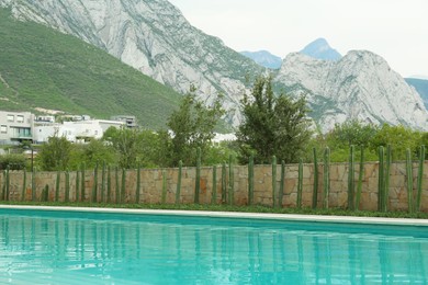 Outdoor swimming pool surrounded by cactuses and mountains on background