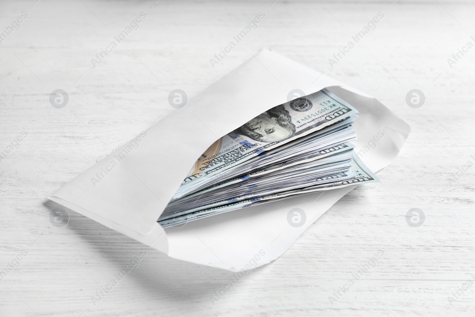 Photo of Envelope with dollar bills on white wooden table. Bribe concept