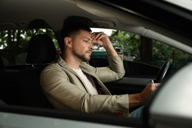 Stressed businessman in driver's seat of modern car