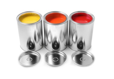 Photo of Cans of orange, yellow and red paints on white background