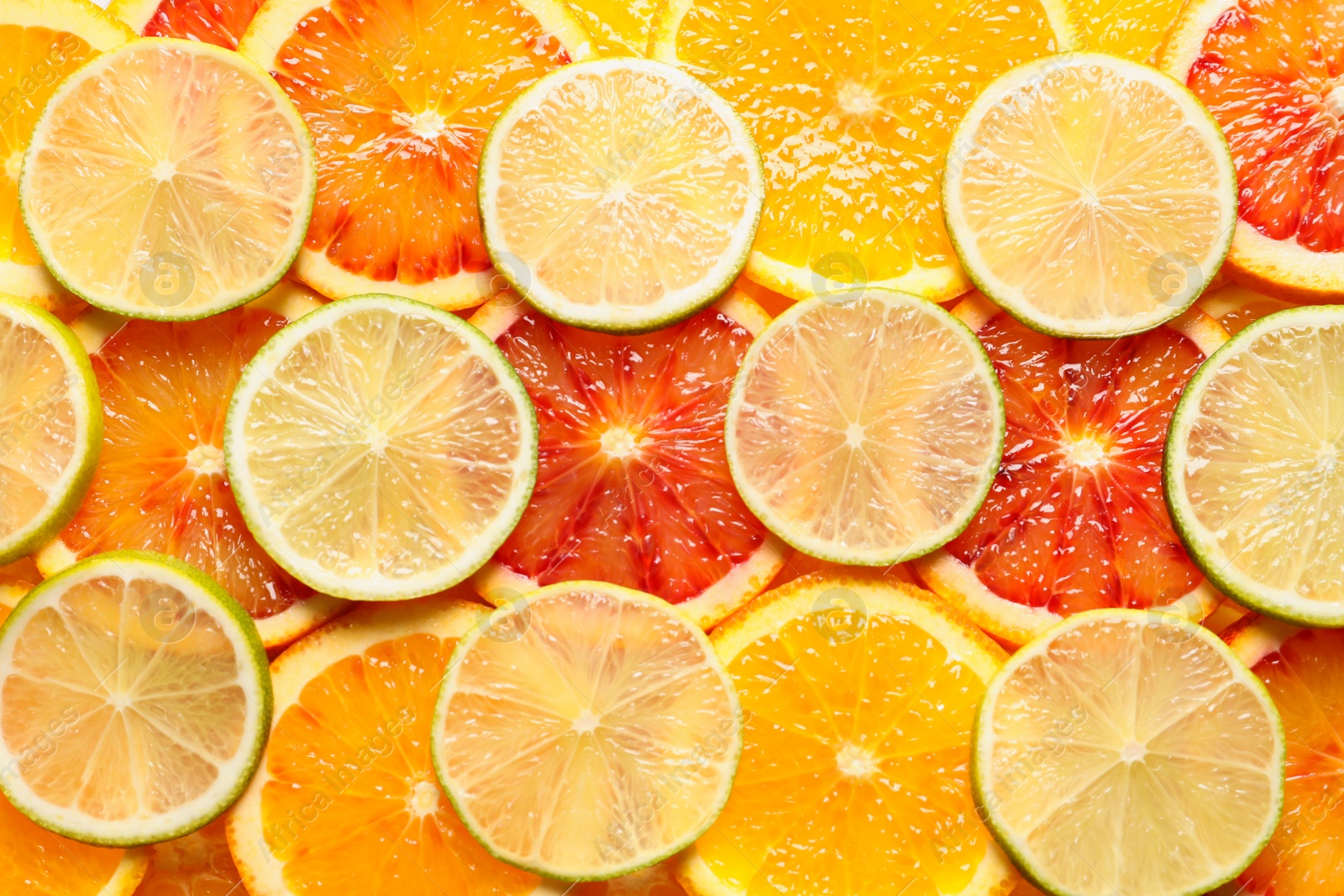 Photo of Slices of fresh citrus fruits as background, top view