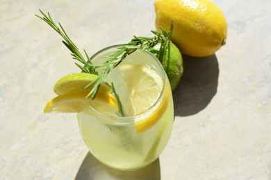 Photo of Tasty refreshing lemonade and ingredients on light table. Summer drink