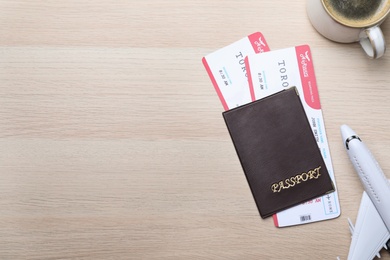 Photo of Flat lay composition with avia tickets and passport on wooden table, space for text. Travel agency concept