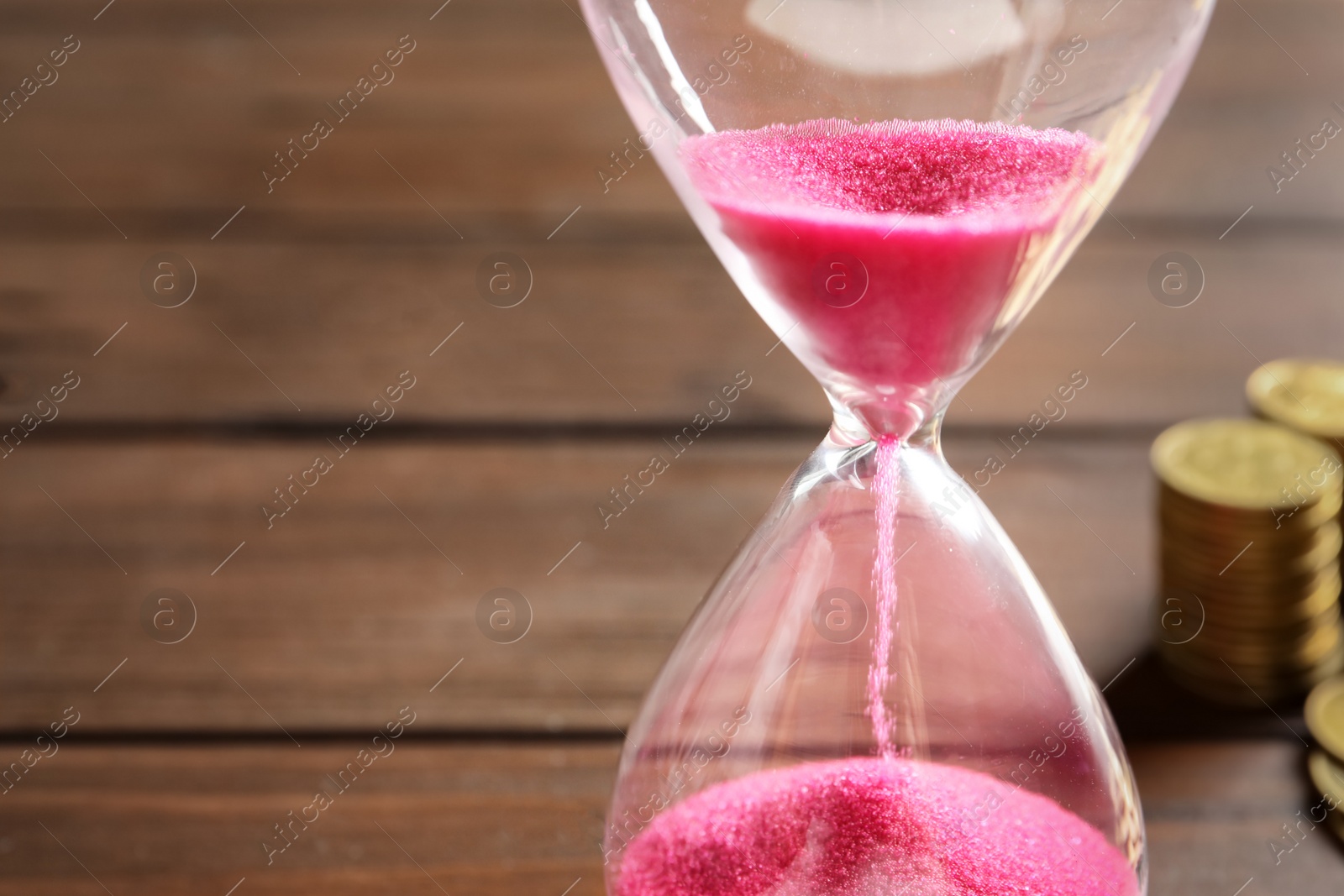 Photo of Hourglass with flowing sand on table, closeup. Time management