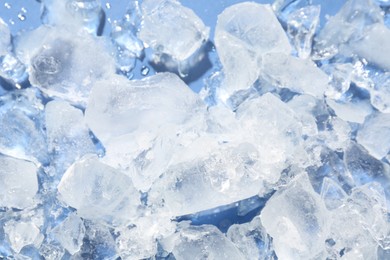 Photo of Pieces of crushed ice on light blue background, above view