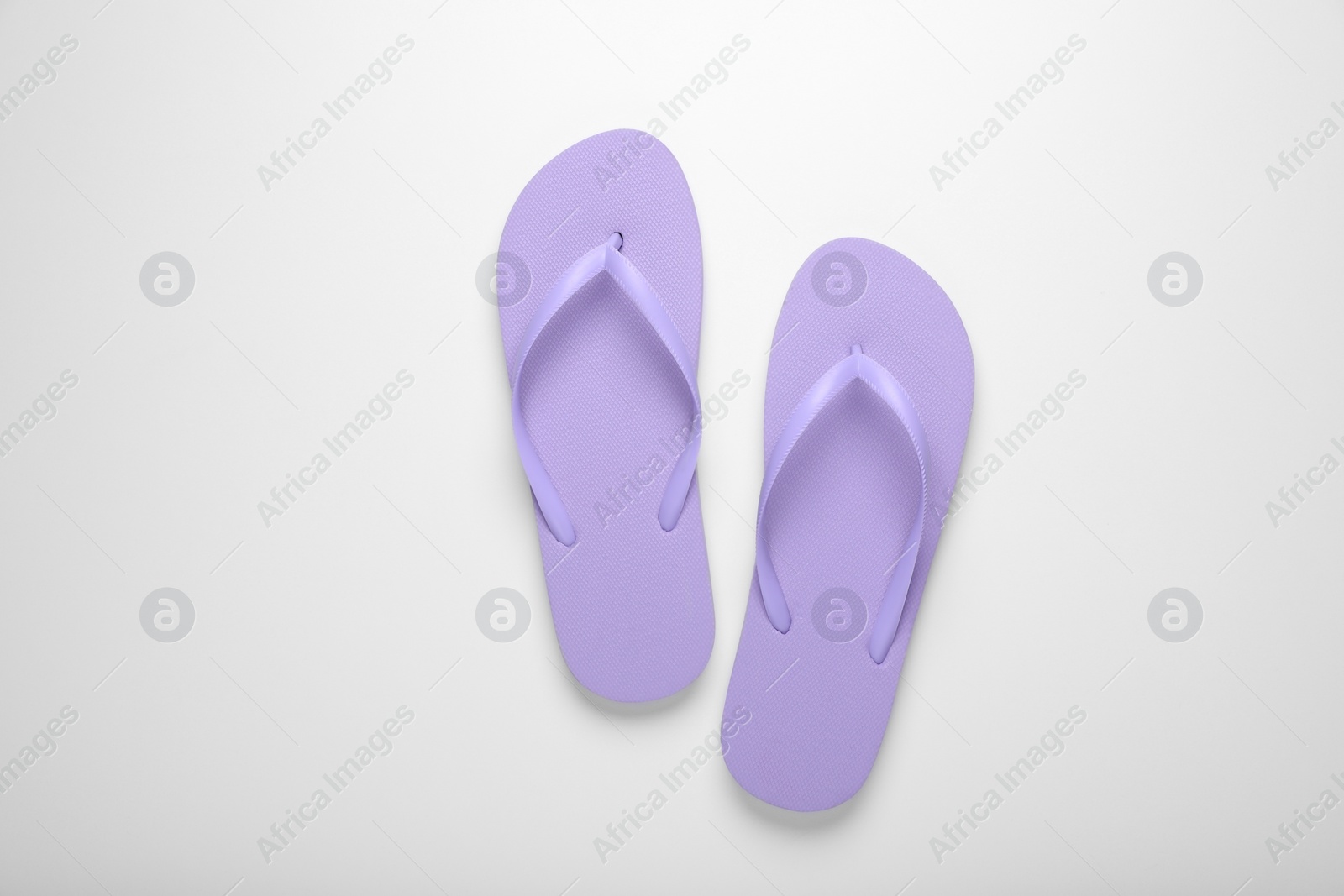 Photo of Stylish violet flip flops on white background, top view