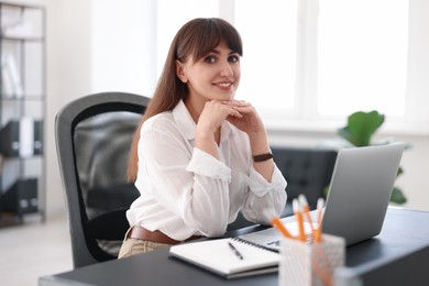 Photo of Woman watching webinar at table in office