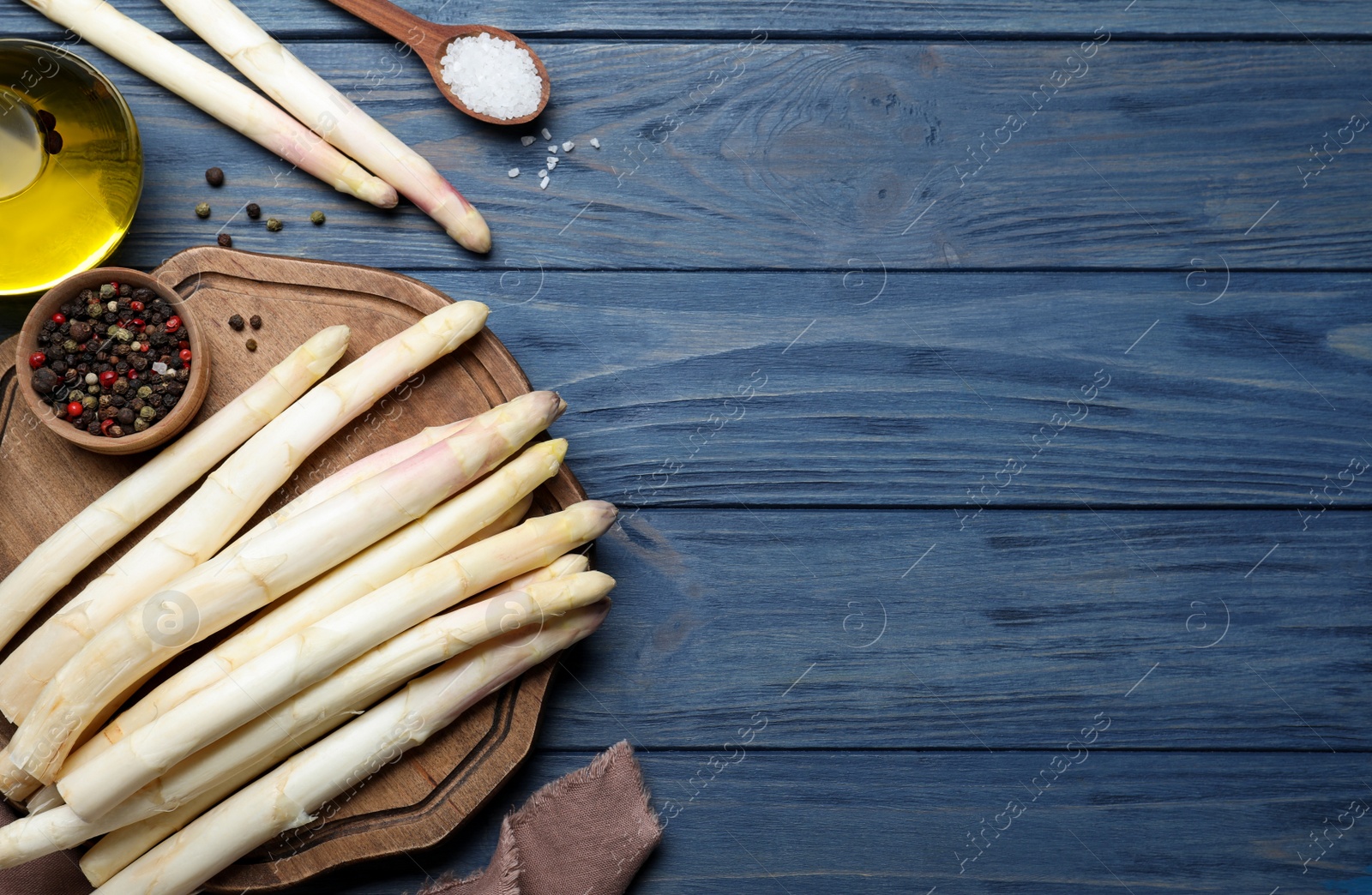 Photo of Flat lay composition with white asparagus on blue wooden table. Space for text