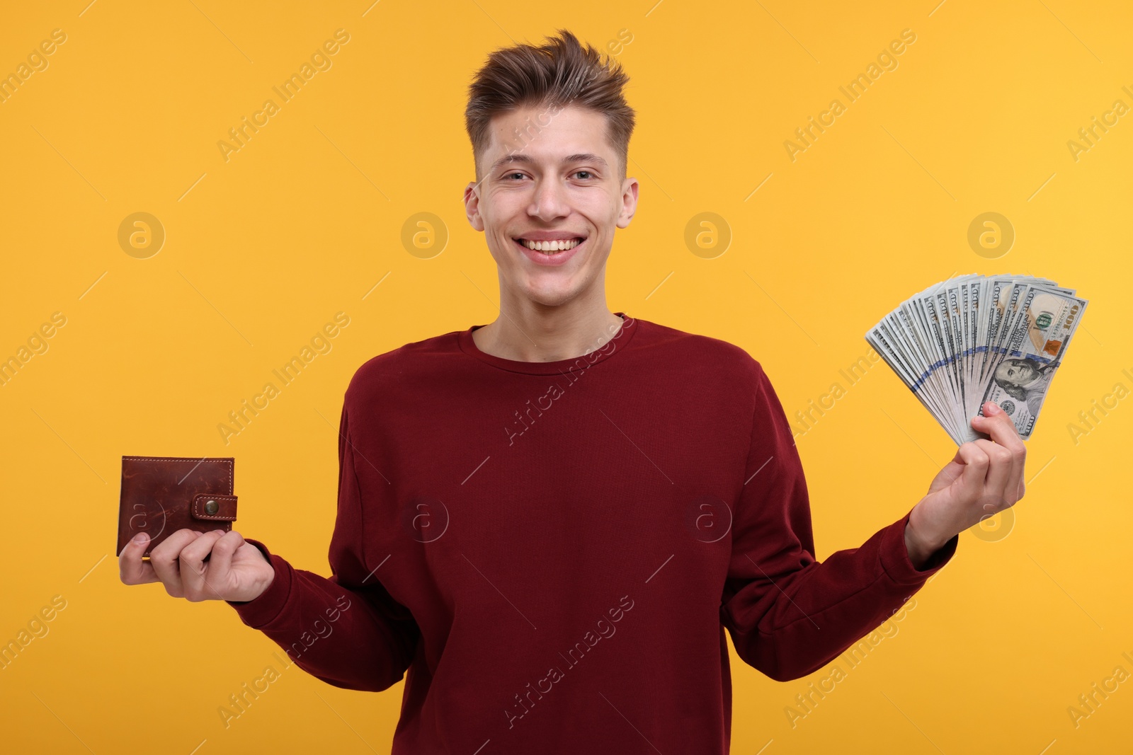 Photo of Happy man with money and wallet on yellow background