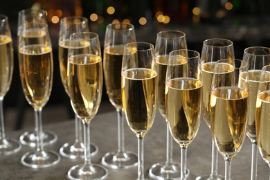 Photo of Glasses of champagne on table against blurred background