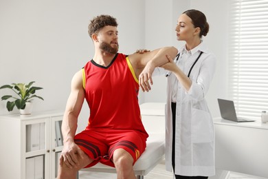 Sports injury. Doctor examining patient's hand in hospital