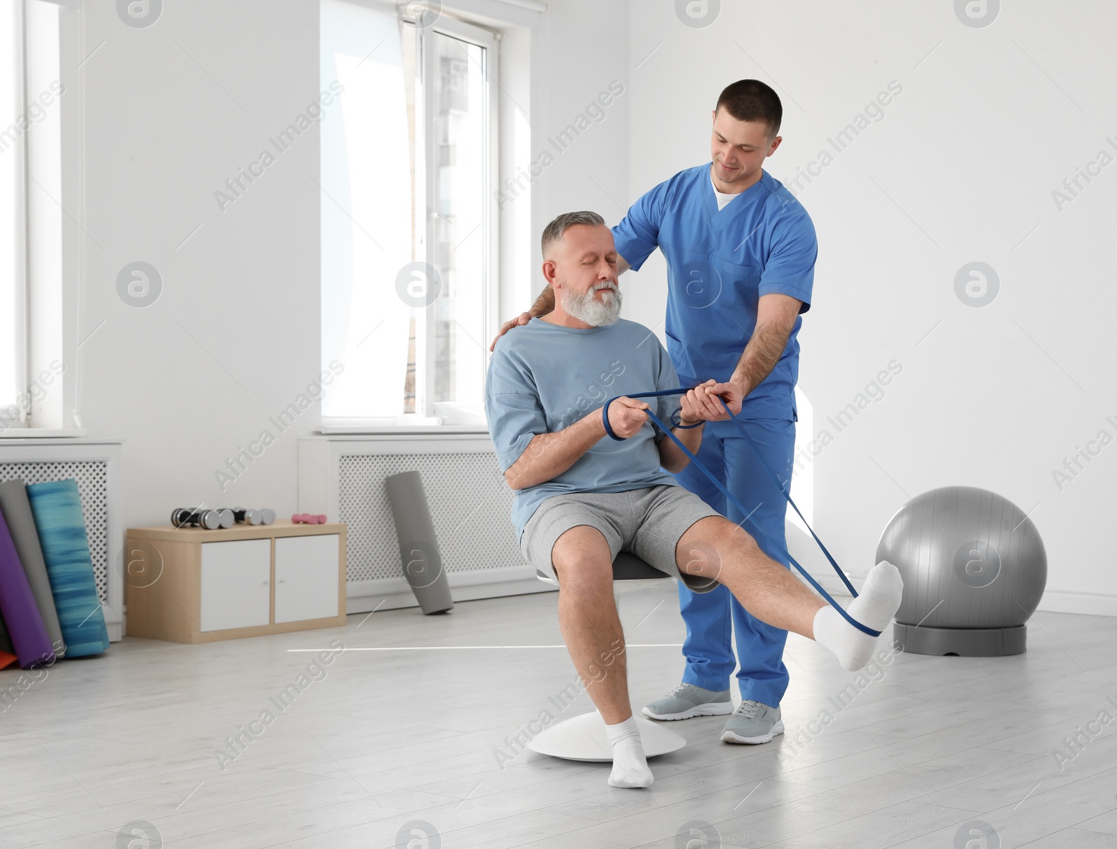 Photo of Professional physiotherapist working with senior patient in rehabilitation center