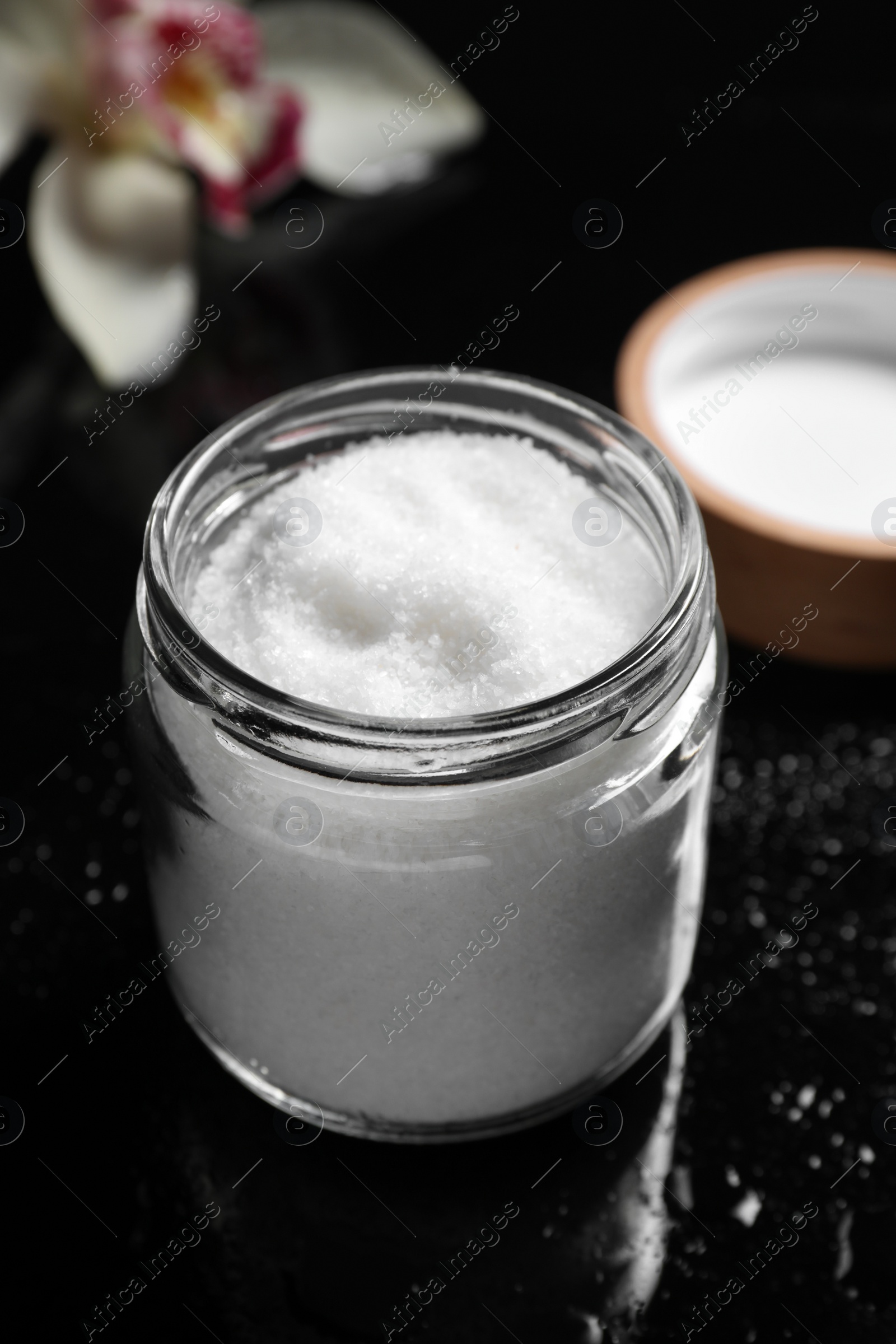 Photo of Jar with natural sea salt on mirror table