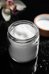 Photo of Jar with natural sea salt on mirror table