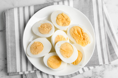 Photo of Tasty hard boiled eggs on ceramic plate, top view