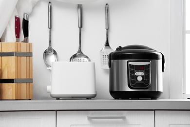 Photo of Modern electric multi cooker and toaster on kitchen countertop