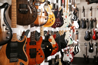 Photo of Rows of different guitars in music store