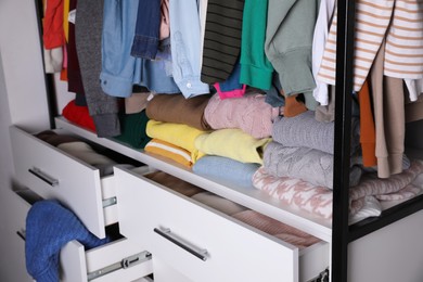 Rack with stylish women's clothes in room, closeup. Fast fashion