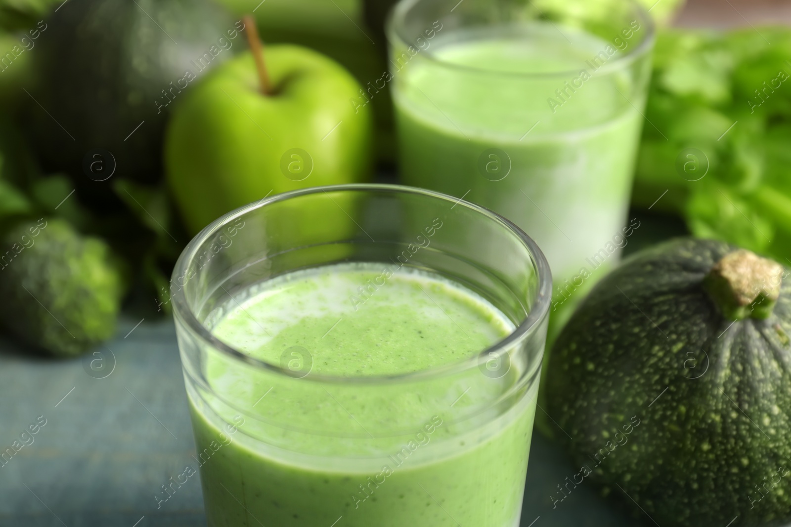 Photo of Glass with healthy detox smoothie and ingredients on table, closeup