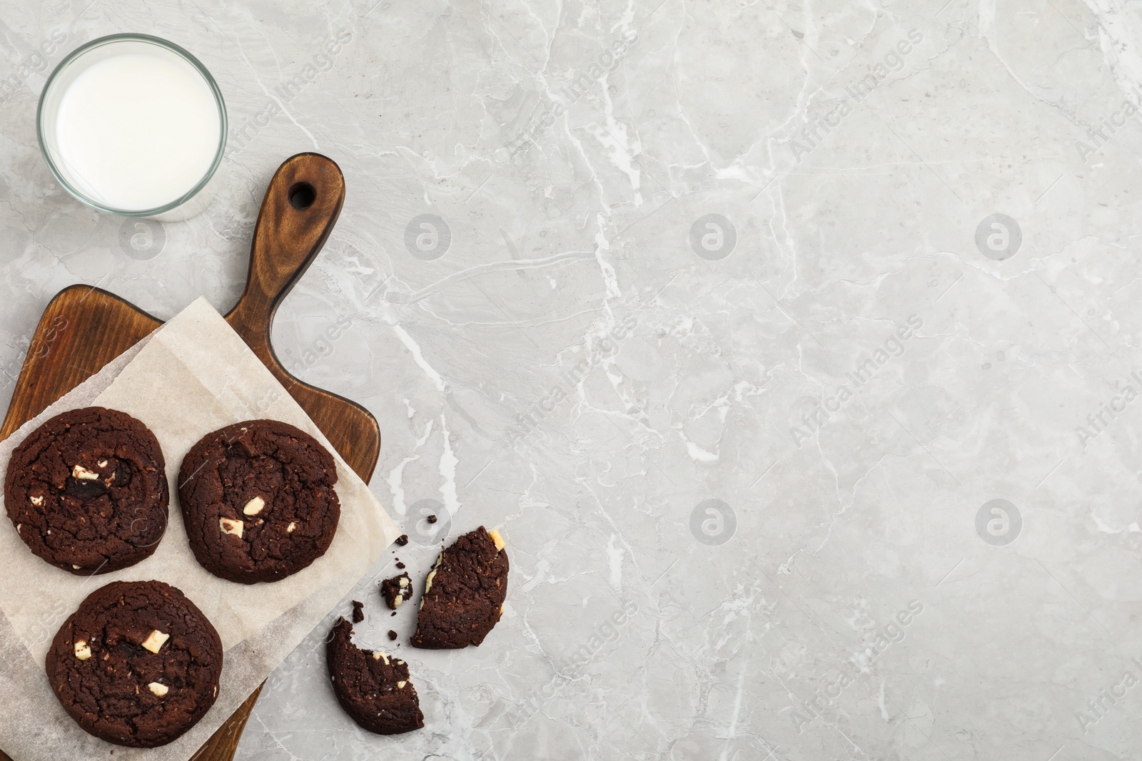 Photo of Delicious chocolate cookies and glass of milk on marble table, flat lay. Space for text