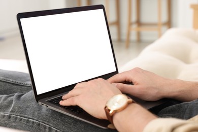 Man working with laptop on sofa at home, closeup