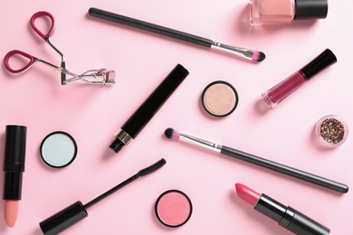 Photo of Flat lay composition with products for decorative makeup on pastel pink background