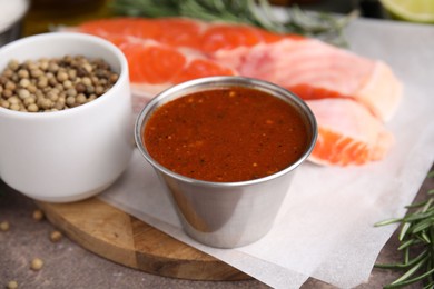 Photo of Tasty fish marinade and products on table, closeup