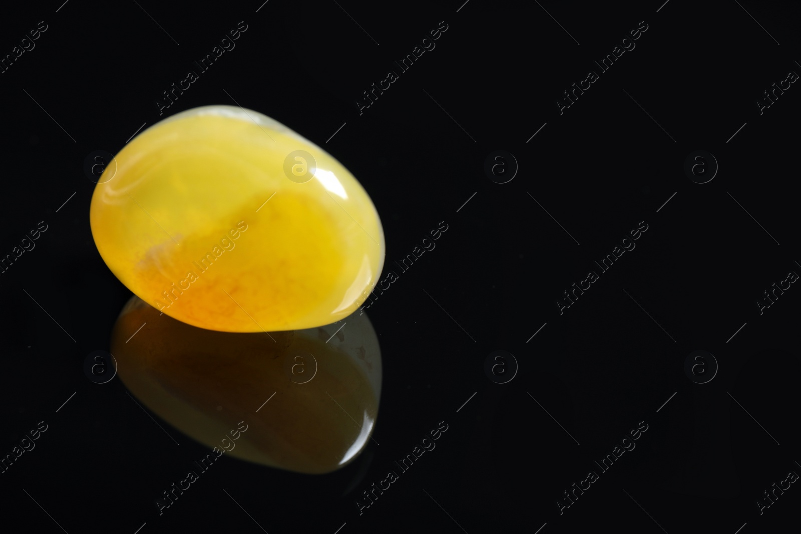 Photo of Beautiful honey agate gemstone on black background. Space for text