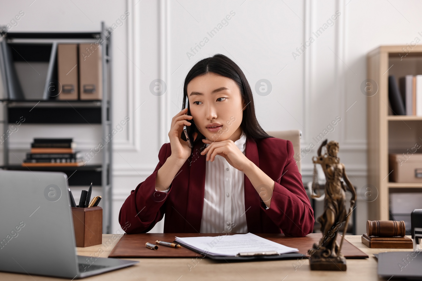 Photo of Notary talking on phone at table in office