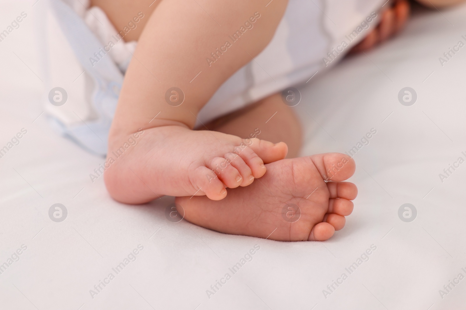 Photo of Newborn baby lying on white blanket, closeup