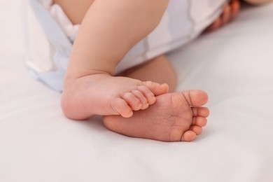 Photo of Newborn baby lying on white blanket, closeup