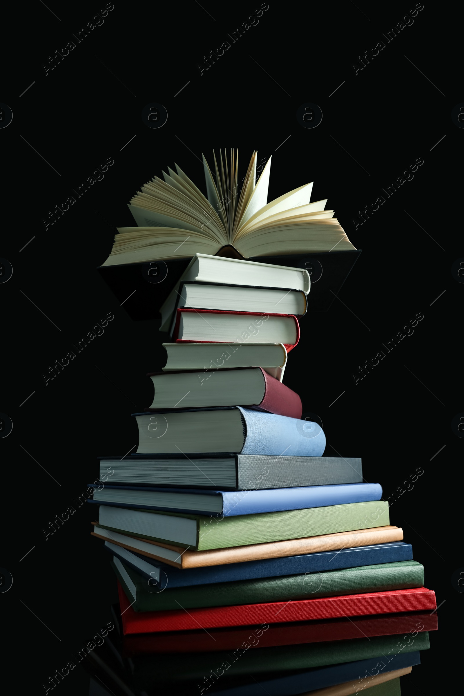 Photo of Stack of different hardcover books on black background