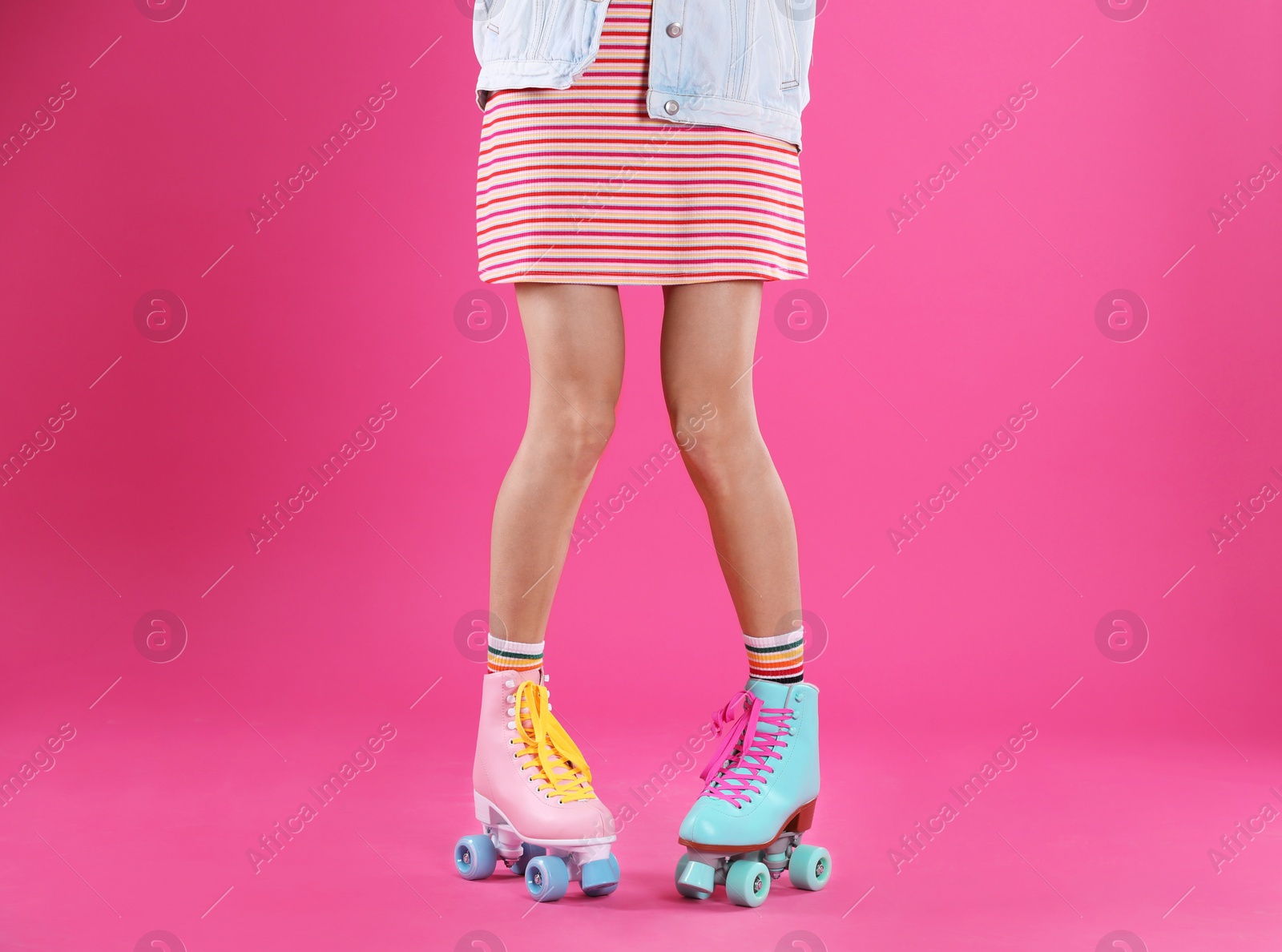 Photo of Young woman with retro roller skates on color background, closeup