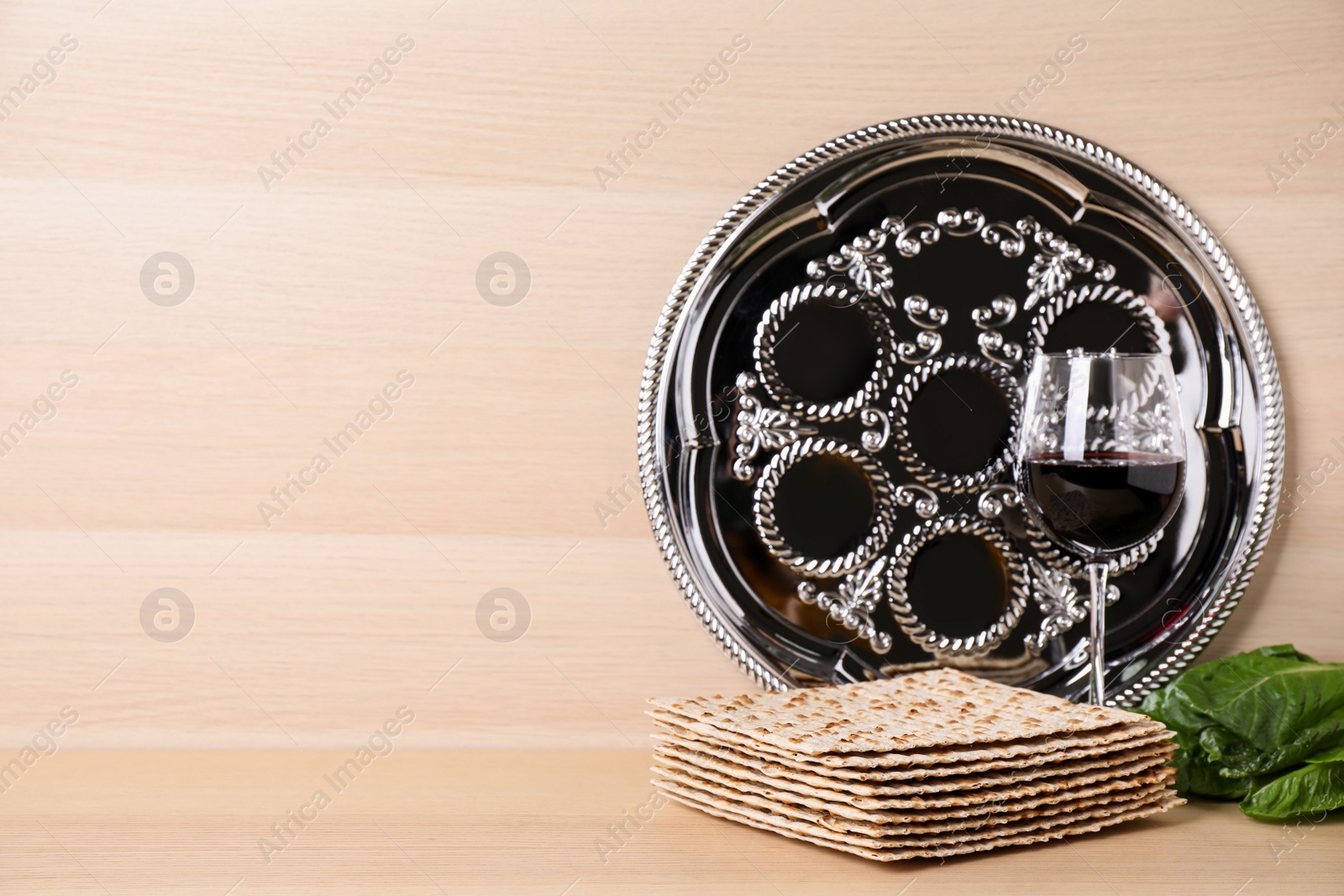 Photo of Symbolic Pesach (Passover Seder) items on wooden table, space for text