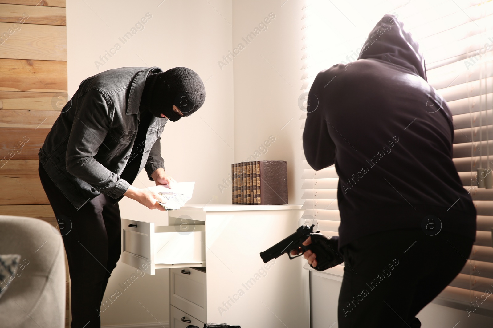 Photo of Dangerous masked criminals with weapon stealing money from house