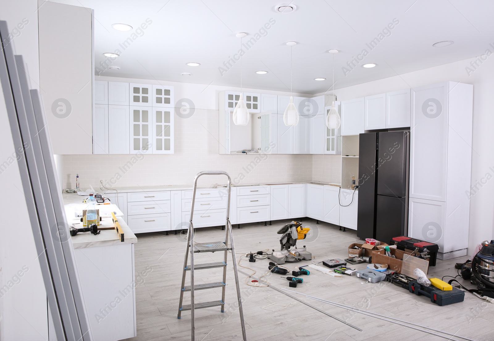 Photo of Renovated kitchen interior with stylish furniture, refrigerator and maintenance equipment