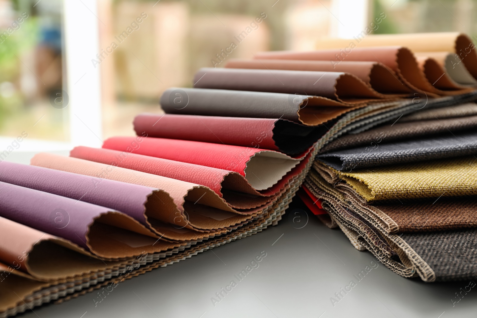 Photo of Fabric and leather samples of different colors for interior design on table