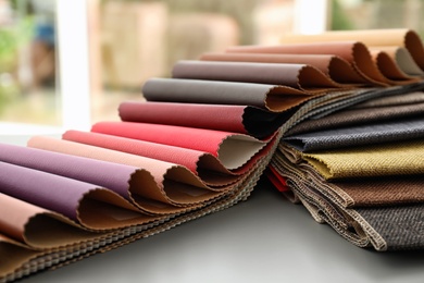 Photo of Fabric and leather samples of different colors for interior design on table