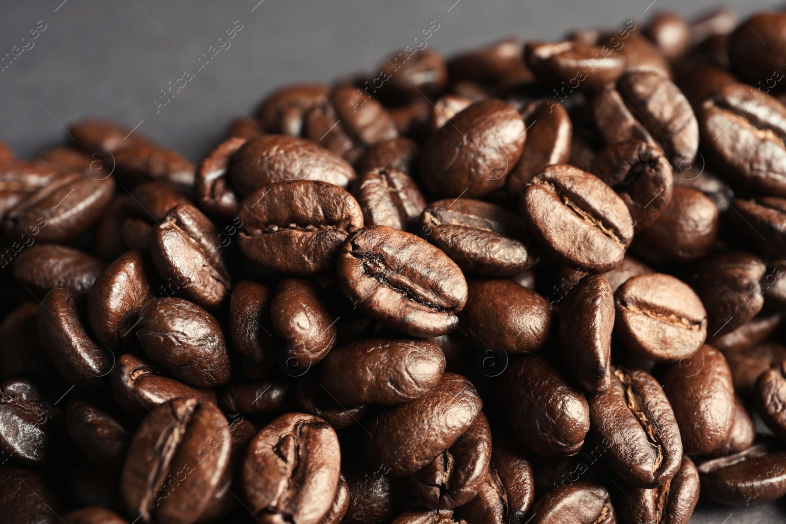 Photo of Roasted coffee beans on grey background, closeup