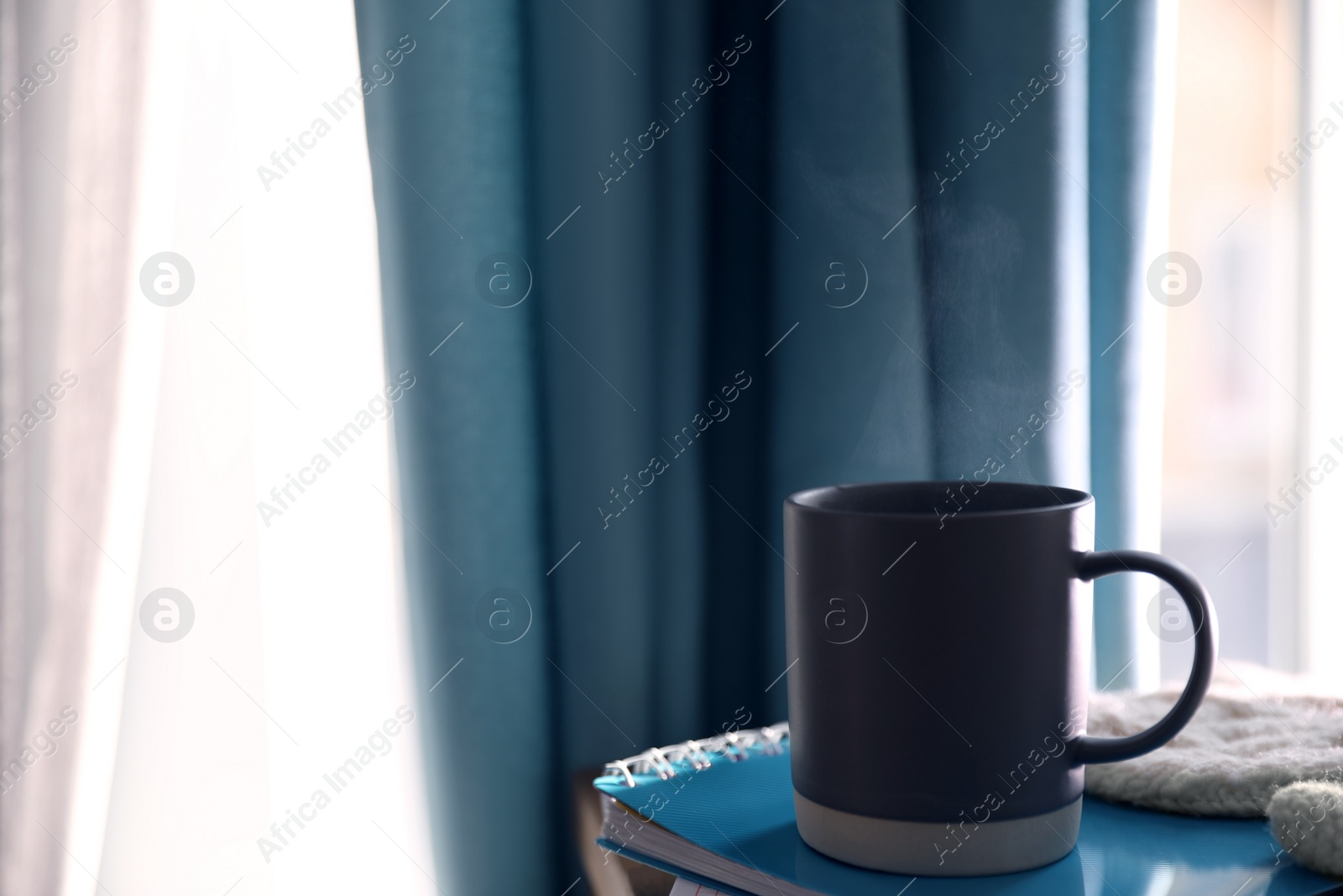 Photo of Delicious morning coffee and notebook near window indoors. Space for text