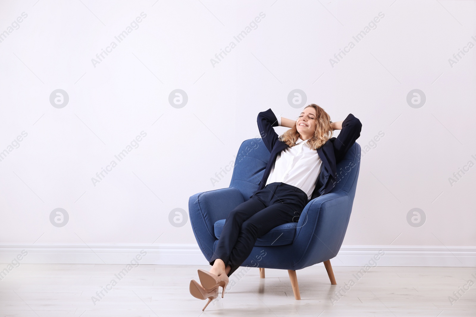 Photo of Young woman sitting in armchair indoors. Space for text