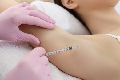 Photo of Cosmetologist injecting young woman's armpit, closeup. Treatment of hyperhidrosis