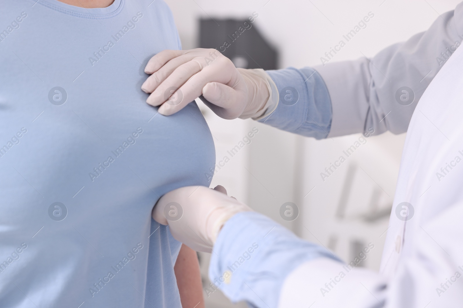 Photo of Mammologist checking woman's breast in hospital, closeup