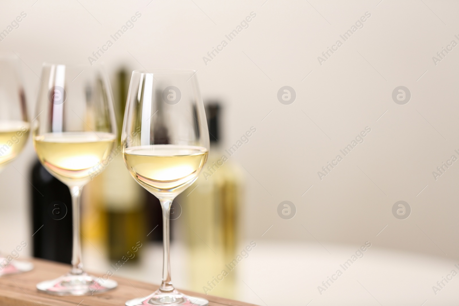 Photo of Glasses of wine on wooden board, space for text